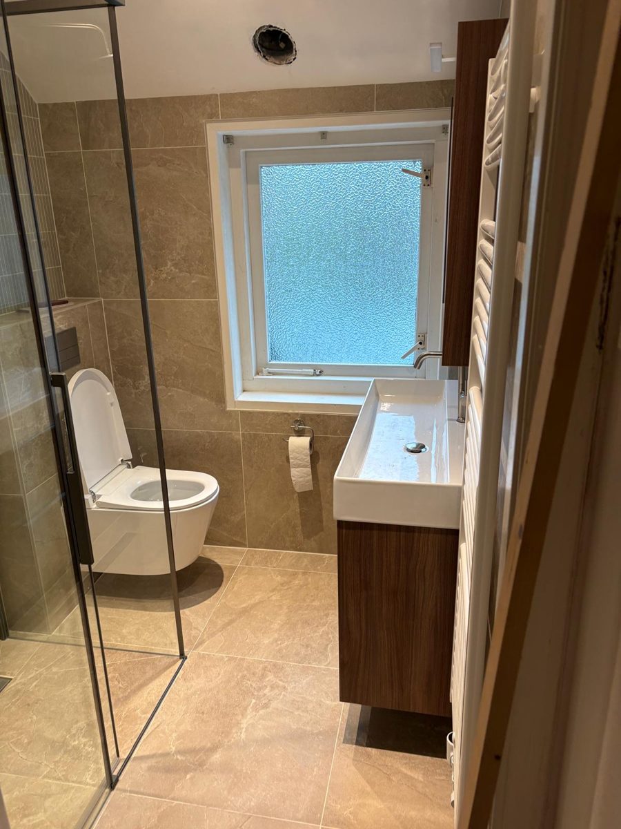Badkamer na de verbouwing: nieuwe tegels, zwevend toilet en nieuw badmeubel
