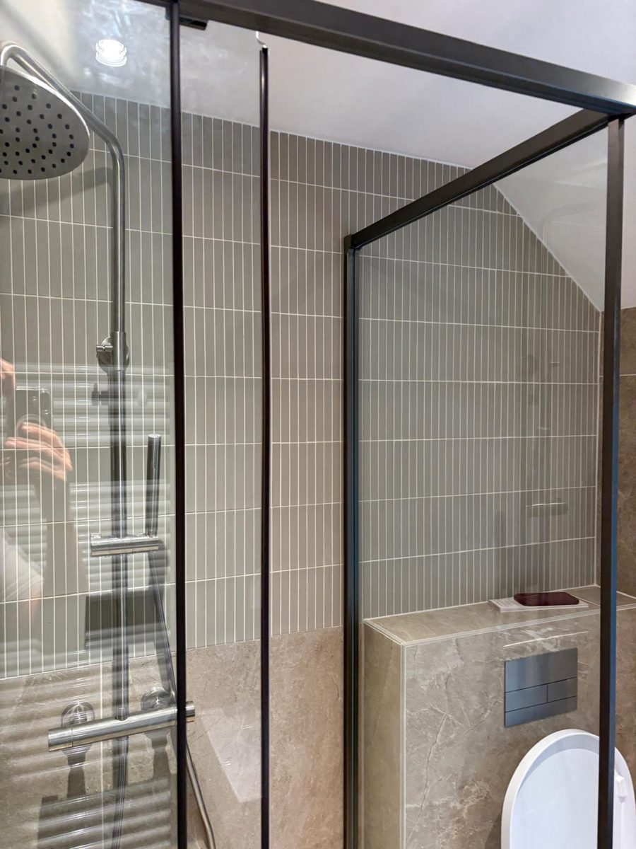 Nieuwe douche met groene strookjestegels en zwarte profielen